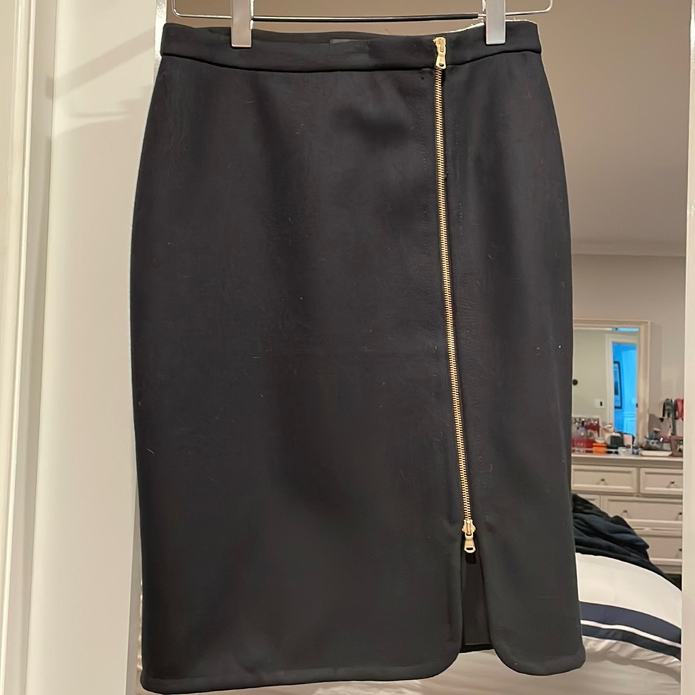 Black pencil skirt with gold front zip.